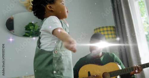 Toddler dancing to guitar music, man strumming and smiling, sparkle effect sweeping over guitar