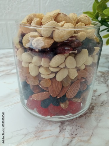 a jar with neatly arranged nuts and candied fruits.