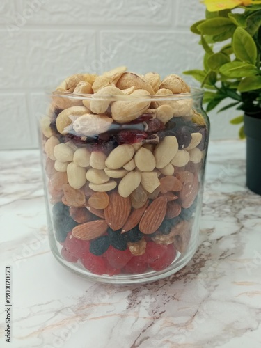 a jar with neatly arranged nuts and candied fruits.