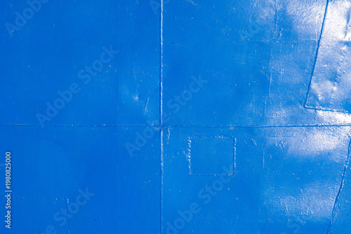 Weathered metal deck floor with welded seams ant thick layer of blue paint.