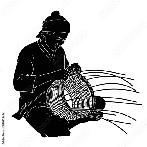 A person skillfully weaves a large basket on the floor