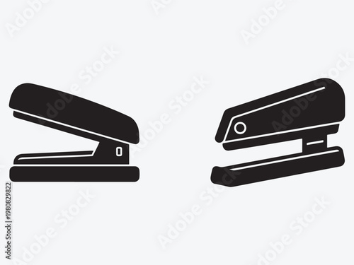 Two black staplers side by side one open and one closed office supplies