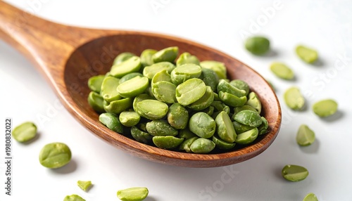 A wooden spoon filled with green beans on a white surface