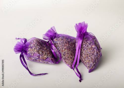 Dried lavender in purple mesh bags on a white background