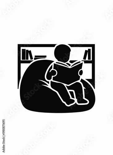 Child reading book on beanbag chair surrounded by bookshelf.