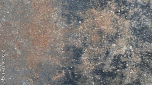 The texture of the old concrete surface with stains and a mix of gray and brownish colors, gives a dirty, rough, and industrial impression as a grunge background.
