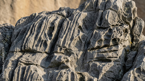 Ancient rock surface with natural carved textures, weathered by wind and rain, geological formation details. travel magazines.