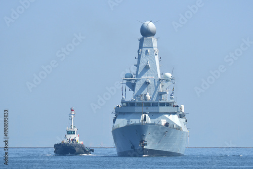 HMS Dauntless Type 45 destroyer of the Royal Navy sailing on Tokyo Bay with tugboat, Japan