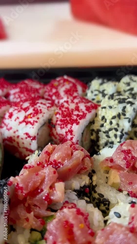 Philadelphia rolls, close-up sushi. Vertical video. Salmon sushi, assorted rice rolls. Ginger and chopsticks.