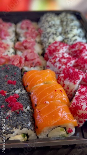 Philadelphia rolls, close-up sushi. Vertical video. Salmon sushi, assorted rice rolls. Ginger and chopsticks.