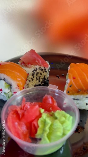 Philadelphia rolls, close-up sushi. Vertical video. Salmon sushi, assorted rice rolls. Ginger and chopsticks.