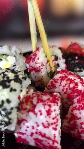 Philadelphia rolls, close-up sushi. Vertical video. Salmon sushi, assorted rice rolls. Ginger and chopsticks.