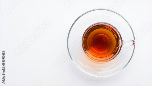 Fotografie Top view of clear glass cup of black tea on saucer with white background and cop