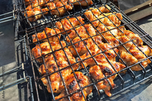 Grilled chicken pieces on barbecue