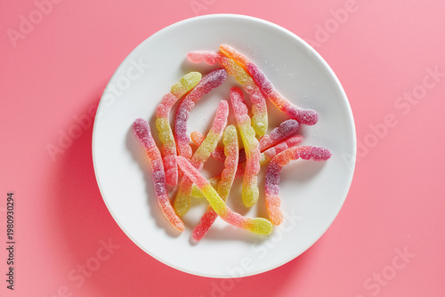 Sour gummy worms on plate.