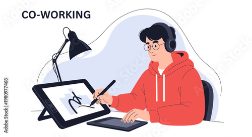 Young man wearing headphones drawing on a graphic tablet in a co-working space