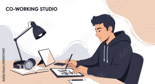 Young man drawing on tablet in co-working studio, modern workspace, creative design