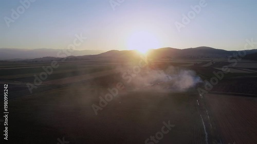 Aerial Drone View of Stubble Burning Fire and Smoke Under Intense Sunlight Over Farmland