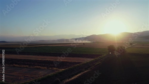 Aerial Drone View of Stubble Burning Smoke in Distant Farmland at Golden Hour