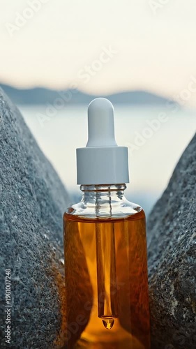 Amber Oil Dropper Bottle Between Rocks With Ocean Background