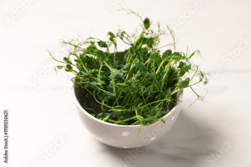 Fresh microgreens on white marble table, closeup