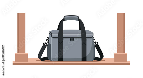 A grey soft-sided cooler bag with black webbing handles and an adjustable shoulder strap rests on a minimalist wooden shelf against a plain white background.