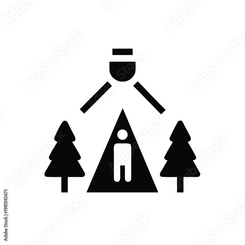 Overhead light source illuminating a lone camper in a tent nestled between towering forest trees