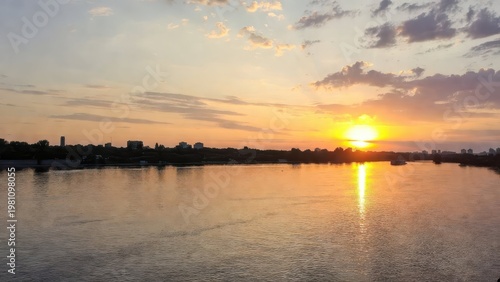 Serene Sunset Over Calm River with Reflections and Silhouettes
