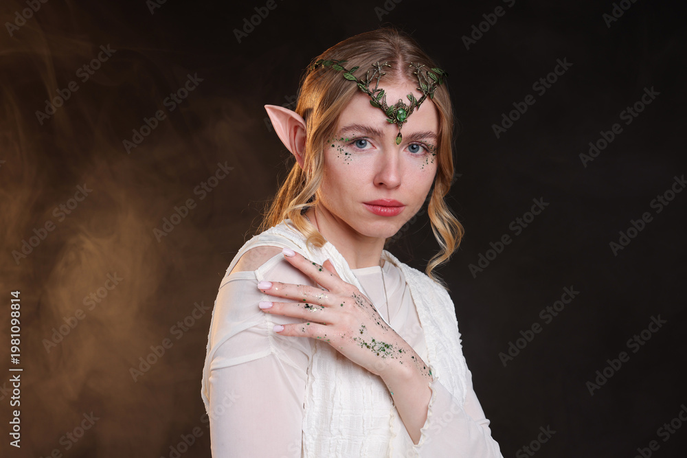 Fototapeta premium Beautiful girl dressed as elf on black background with smoke