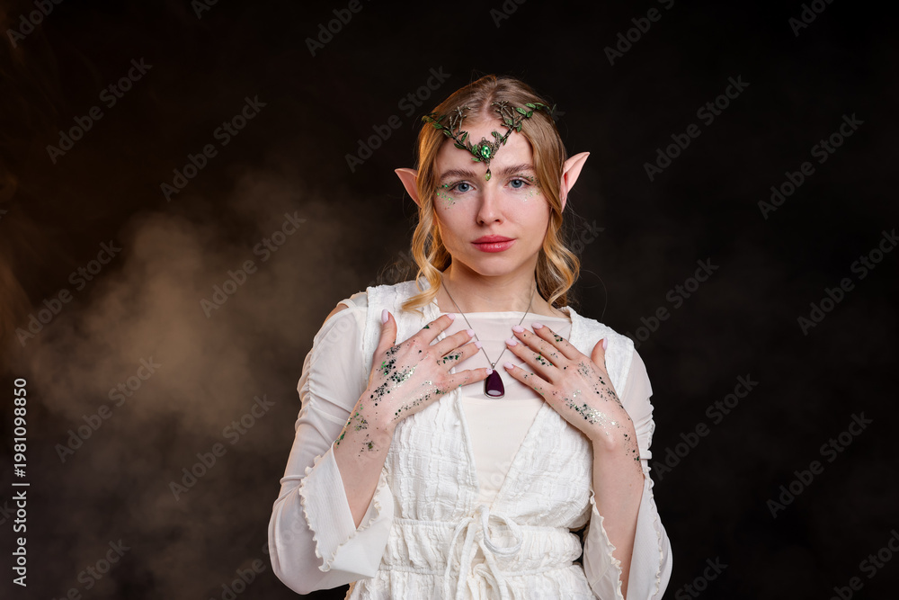 Fototapeta premium Beautiful girl dressed as elf on black background with smoke