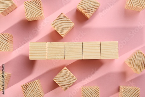 Many blank wooden cubes on pink background, flat lay. Space for text