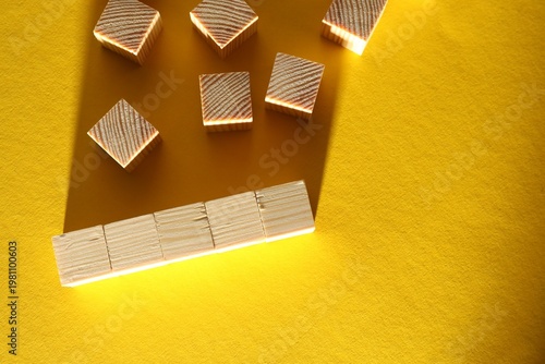 Many blank wooden cubes on yellow background, flat lay. Space for text