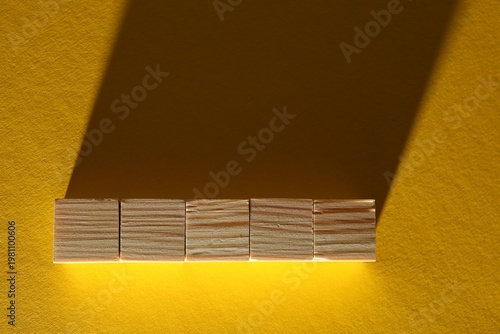 Blank wooden cubes on yellow background, flat lay. Space for text