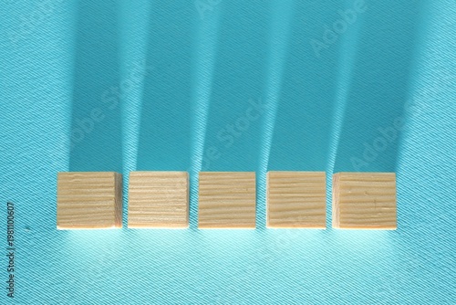 Blank wooden cubes on turquoise background, flat lay. Space for text