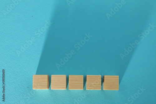 Blank wooden cubes on turquoise background, flat lay. Space for text