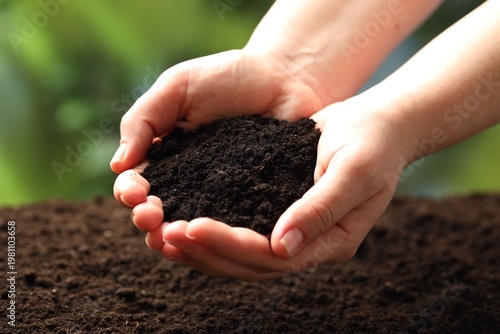 Woman with fresh soil on blurred background, closeup