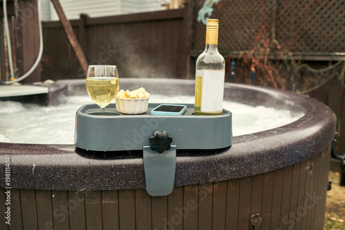 Fotografie A high-angle close-up shot of a functional grey hot tub side table securely clamped onto the rim of a bubbling jacuzzi