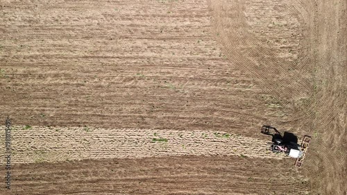 Aerial Drone View of Tractor Plowing Agricultural Field with Patterned Farmland