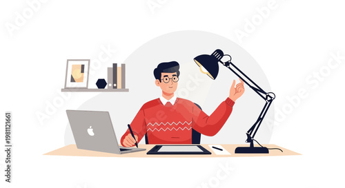Designer working on laptop and tablet with desk lamp in home office