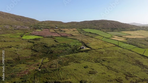 Wallpaper Mural This shows a beautiful aerial perspective of the Irish countryside, featuring lush green patchwork fields and isolated homes amidst gently rolling hills under a bright blue sky during daytime. Torontodigital.ca