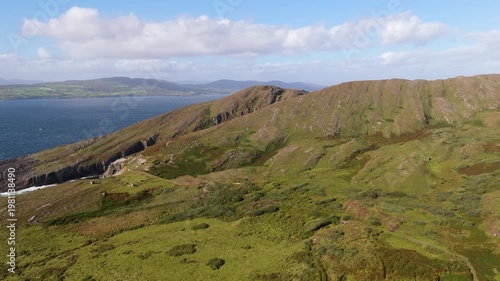 Wallpaper Mural Expansive aerial landscape showcases rugged green hills, steep ocean cliffs, and the deep blue Atlantic Ocean under a bright sky with scattered white clouds in West Cork, Ireland. Torontodigital.ca