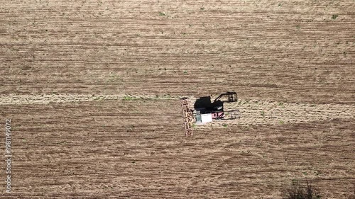 Aerial Drone View of Tractor Plowing Agricultural Field with Patterned Farmland