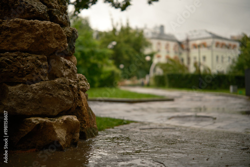 Cinematic rain falling on granite stone with park view. Perfect for nature, weather, and urban themes.