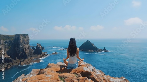 Woman Meditating on Rocky Cliff Overlooking Tranquil Ocean Scene