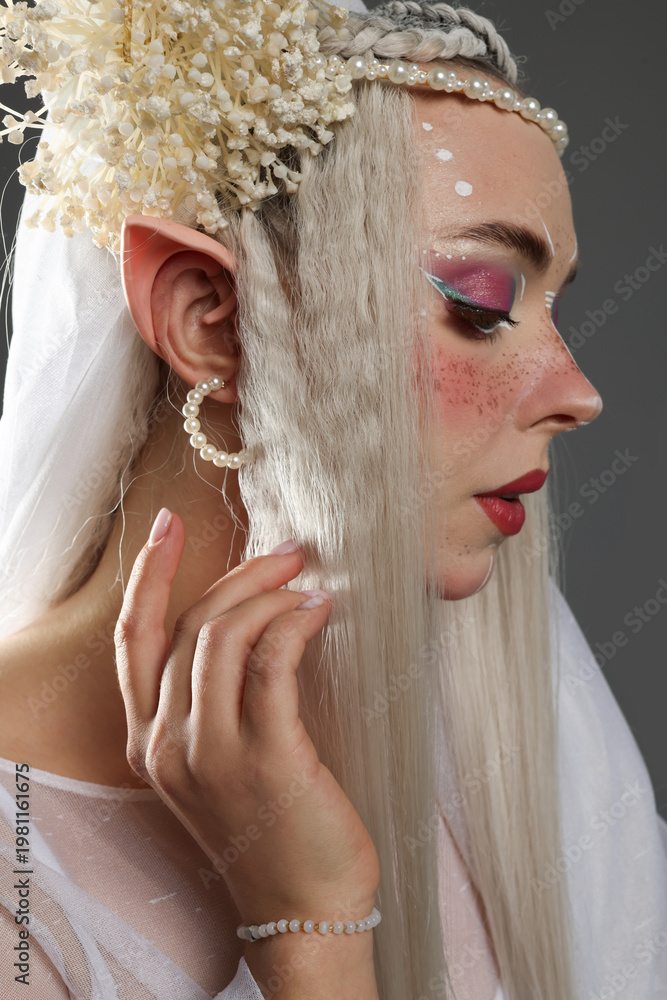 Naklejka premium Beautiful girl dressed as elf on grey background