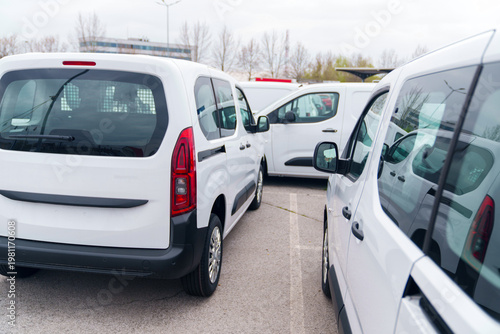 Billede på lærred White delivery vans are parked in rows