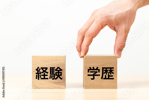 「学歴」と書かれたブロックを選ぶ手元