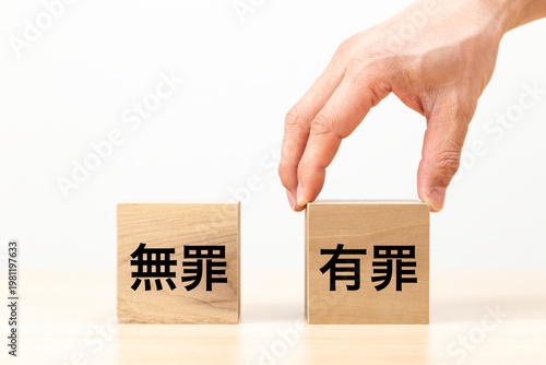 Fotografie 「有罪」と書かれたブロックを選ぶ手元