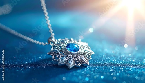 Silver ornate pendant with a blue gemstone center on a sparkling blue surface