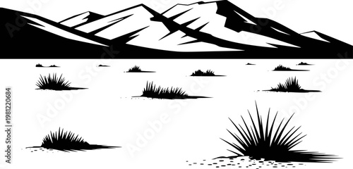 Black and white silhouette of jagged mountain range above sparse desert grass clumps